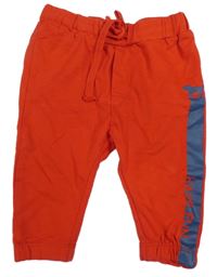 Červené tepláky s pejskem a nápisem Prénatal