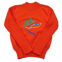 Červený pletený sveter s lesem a lyžařem a rebrovanymi rukávy
