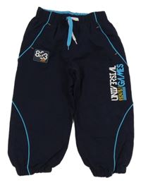 Tmavomodré šušťákové podšité nohavice s nápismi a nášivkou Rebel