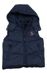 Tmavomodrá šušťáková zateplená vesta s nášivkou a kapucňou