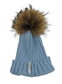 Modrá pletená čepice s kožešinovou bambulí 