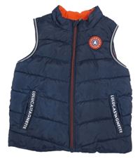 Tmavomodrá prešívaná šušťáková zateplená vesta s nášivkou