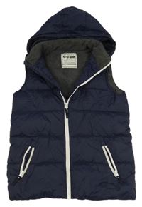 Tmavomodrá šusťáková prošívaná zateplená vesta s kapucí 