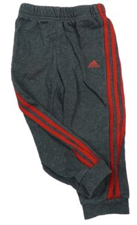 Tmavošedé tepláky s červeným pruhy a logem Adidas