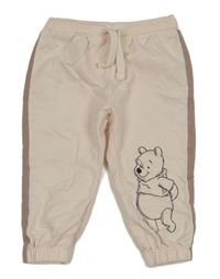 Světlepudrovo-hnědé tepláky s Pú Disney