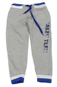 Šedé tepláky s nápisem a pruhovanými lemy 