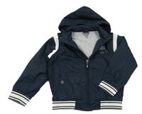 Tmavomodro-bílý šusťákový jarní bomber s nášivkami a ukrývací kapucňou Chicco