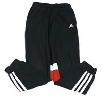 Čierne tepláky s bílými a červenymi pruhmi a logom Adidas