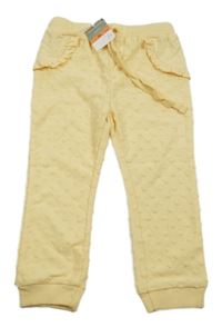 Nové - Žluté puntíkaté tepláky s volánky Sinsay