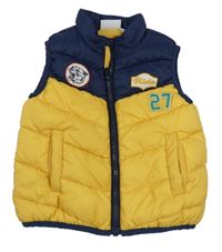 Tmavožluto/tmavomodrá prošívaná šusťáková zateplená vesta s číslem a nášivkami 