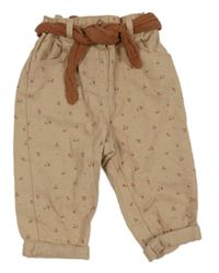 Béžové rifle s kytičkami a páskem Kiabi