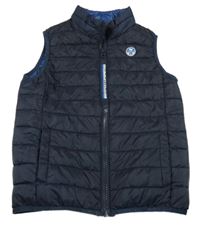 Tmavomodrá šušťáková zateplená vesta s nášivkou