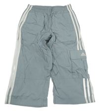 Sivé šušťákové crop nohavice s pruhmi a logom Adidas