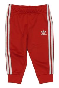 Červené sportovní tepláky s pruhy a logem Adidas