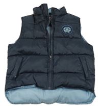 Tmavomodro-modrá prešívaná šušťáková zateplená vesta s nášivkou a nápisom